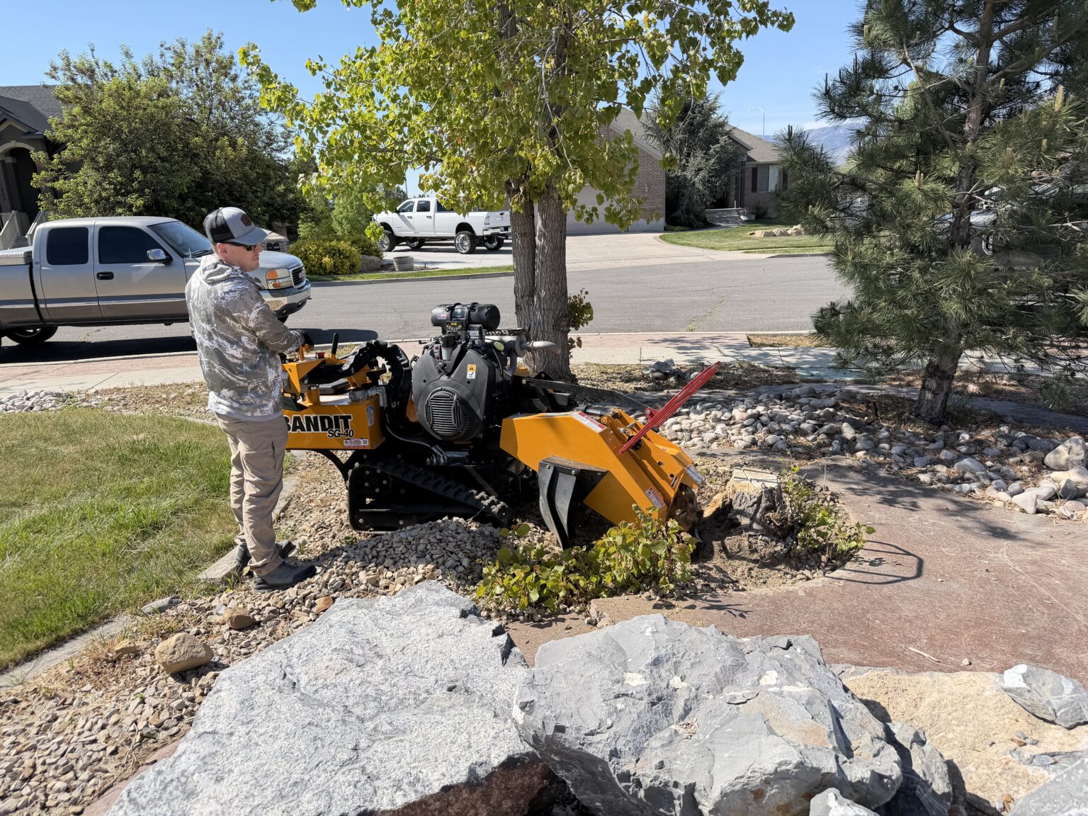 Owner of 801 Stump Grinding operating a Bandit SG-40 stump grinder to remove a tree stump in a residential yard in Utah County, Utah.